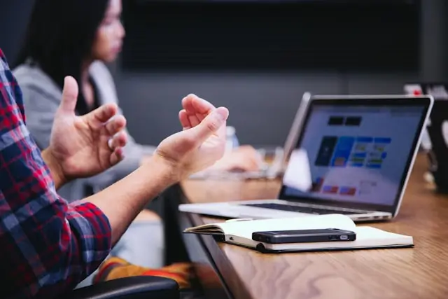 Person explaining something while using a laptop