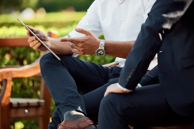 Person showing someone else something on a tablet