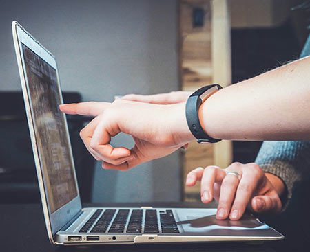 Person pointing to a computer screen