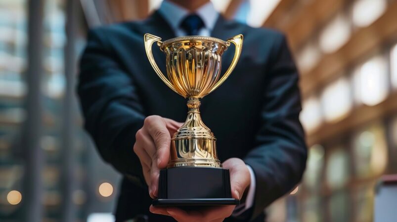 Closeup of businessman holding a trophy