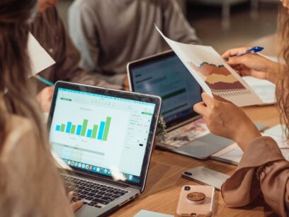 A team of business people reviewing charts on laptops and printed reports